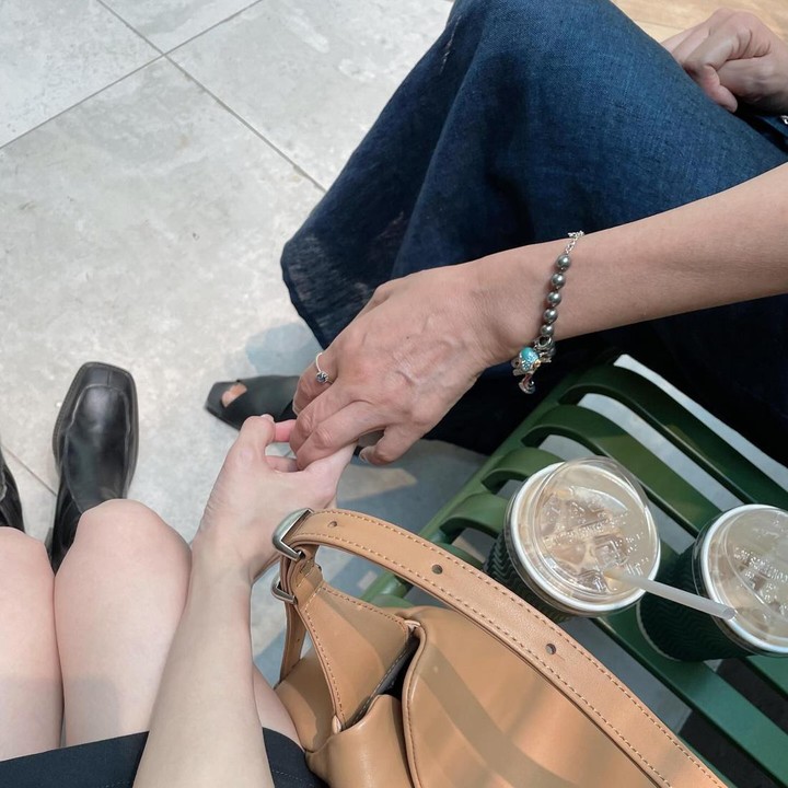 <p>Meski tak menampilkan potret wajah sang Bunda, Jung Somin membagikan foto ketika dirinya menggandeng tangan ibunda saat jalan-jalan. (Foto: Instagram @somin_jj)</p>
