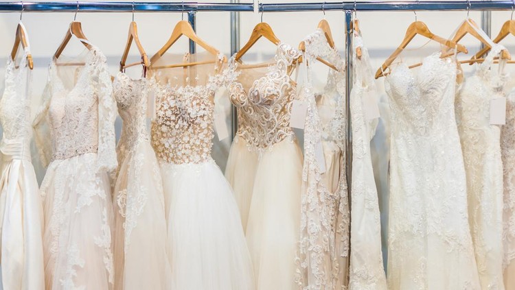 Many beautiful wedding dresses hang in the store