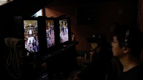A director monitors from vertical screens on the set of a micro movie during a filming session at a banquet hall, in Zhengzhou, Henan province, China July 16, 2024. REUTERS/Tingshu Wang