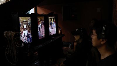A director monitors from vertical screens on the set of a micro movie during a filming session at a banquet hall, in Zhengzhou, Henan province, China July 16, 2024. REUTERS/Tingshu Wang