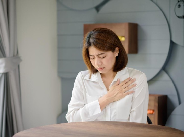 An Asian woman clutched her chest due to suffering from a sudden heart attack.