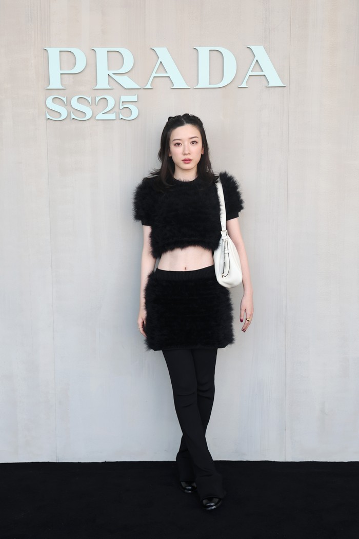 Aktris asal Jepang, Mei Nagano, jatuhkan pilihan pada setelan crop top dan rok. Tekstur fur pada outfit serta padanan shoulder bag putih jadi daya tarik look-nya/ Foto: Getty Images for Prada/Vittorio Zunino Celotto