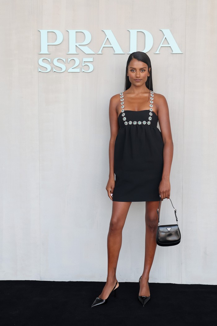 Simone Ashley manjakan mata lewat penampilan simpel, tapi tetap chic. Pilihan busana jatuh kepada mini dress dengan aksen bunga dari kristal sebagai square neckline. Menguatkan kesan chic adalah Prada Cleo bag dan pointy heels yang dikenakannya/ Foto: Getty Images for Prada/Vittorio Zunino Celotto