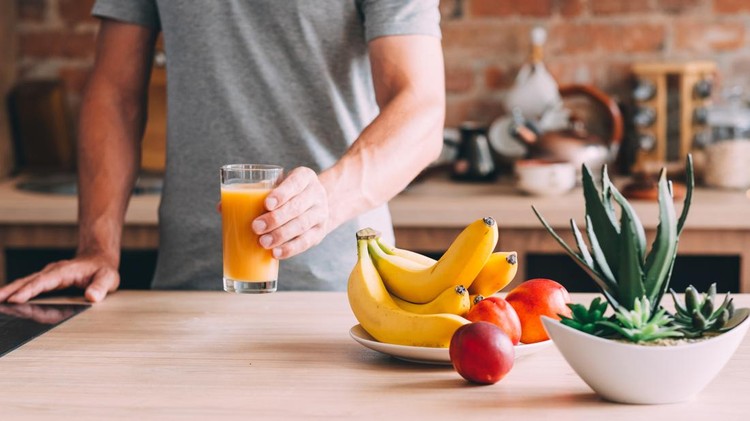 Makan buah Healthy habit. Balanced diet and nutrition. Cropped shot of man holding fresh fruit juice glass. Organic banana, nectarine drink.