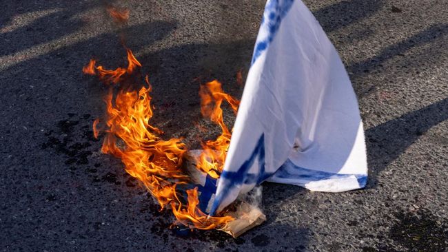 Bendera nasional Israel terbakar saat para pengunjuk rasa berdemonstrasi menentang Israel menyusul terbunuhnya pemimpin Hizbullah Lebanon Sayyed Hassan Nasrallah dalam serangan udara Israel di Beirut, dekat Konsulat Israel di Istanbul, Turki, 29 Sept