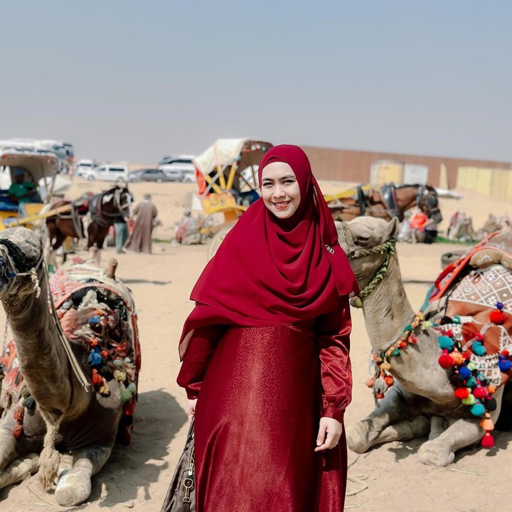 <p>Bunda empat anak itu tampil memesona dalam balutan busana muslimah warna merah yang terlihat menyala di tengah pemandangan gurun pasir. (Foto: Instagram @okisetianadewi)</p>