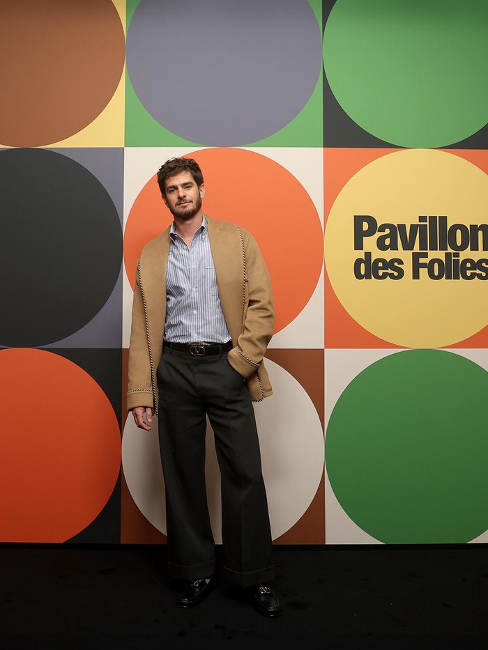 Head-to-toe Valentino seperti undangan lainnya, OOTD Andrew Garfield tampak berbeda karena bernuansa semi-formal. Sang aktor berbalutkan jaket rona camel ditumpuk kemeja bergaris, serta loose pants senada dengan loafers/ Foto: Courtesy of Valentino
