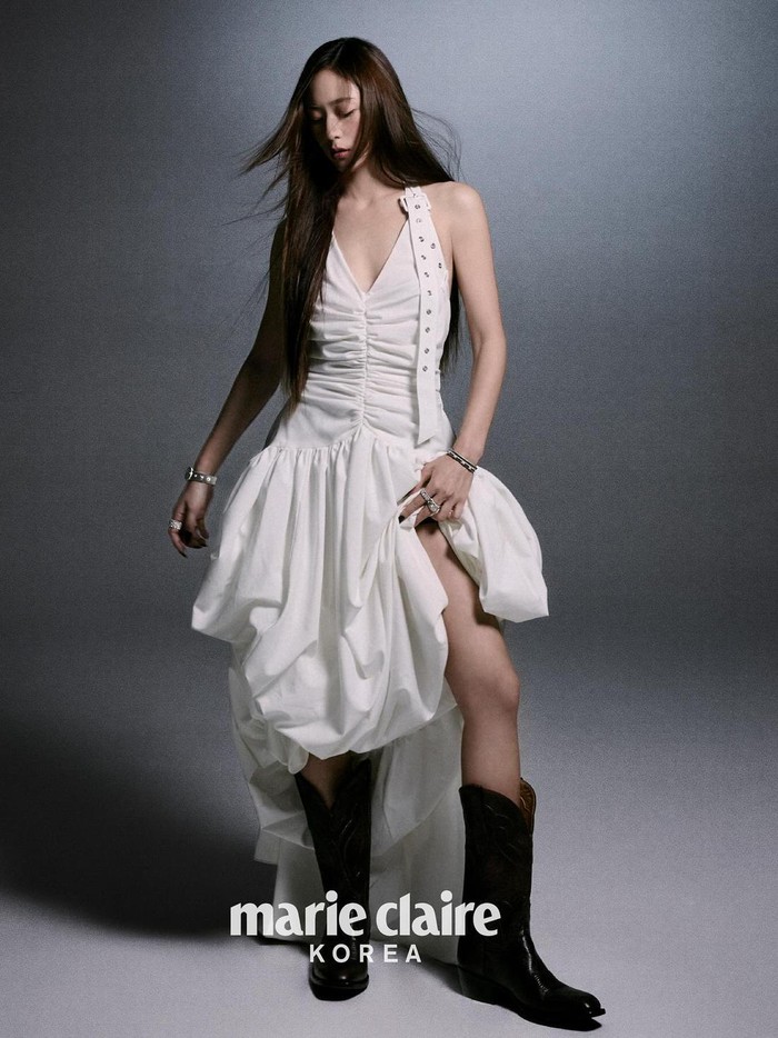 Dengan tampilan royal fairy dress putih yang unik dipadukan dengan sepatu boots, Krystal berhasil menciptakan kesan boyish tanpa menghilangkan nuansa feminin yang anggun. Kombinasi ini sangat cocok padanya./ Foto: X.com/marieclairekr