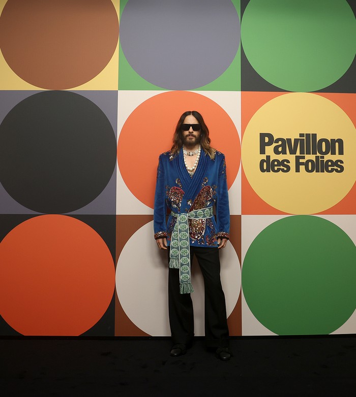 Lain halnya dengan Jared Leto yang justru atraktif bergaya maksimalis. Artis berbakat ini memadukan blazer yang berhias payet membentuk motif paisley dengan ikat pinggang berbordir warna hijau. Kalung mutiara choker dan pendant dipasang bertumpuk untuk menambah pesona gayanya/ Foto: Courtesy of Valentino
