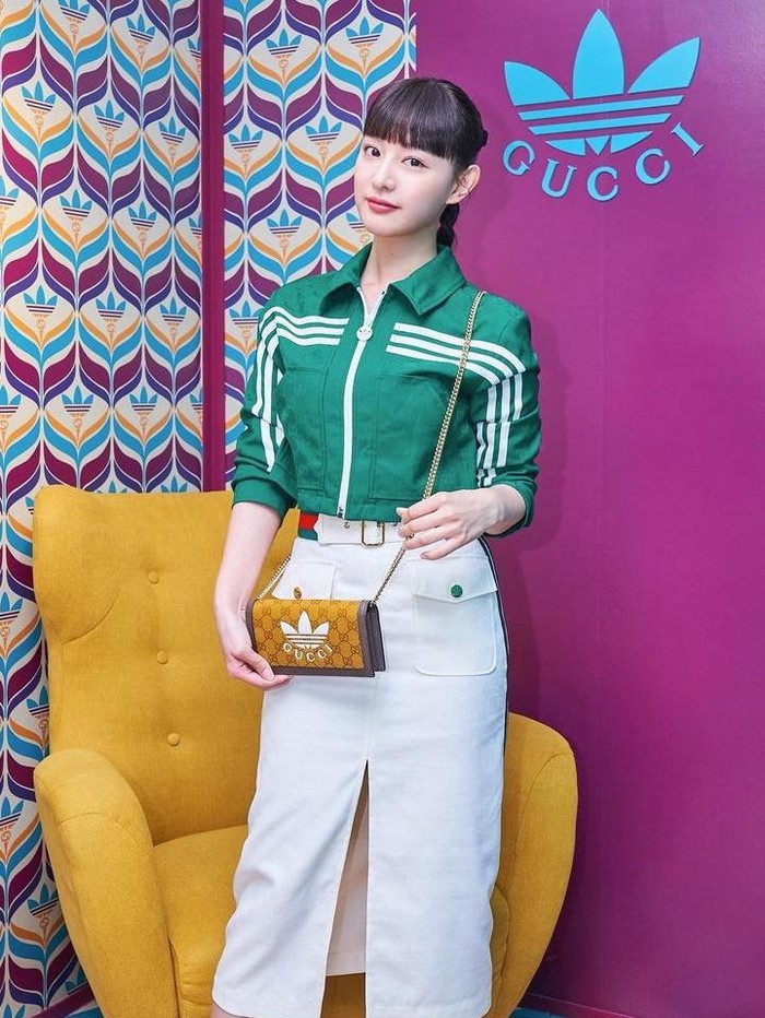 Kim Ji Won tampil chic kala menghadiri event kolaborasi adidas x Gucci pada 2022. Ia memadukan jaket crop hijau dengan rok putih dan sepatu berwarna senada. Gaya rambut ponytail membuat Kim Ji Won tampak lebih sporty dan youthful./ Foto: Instagram/geewonii
