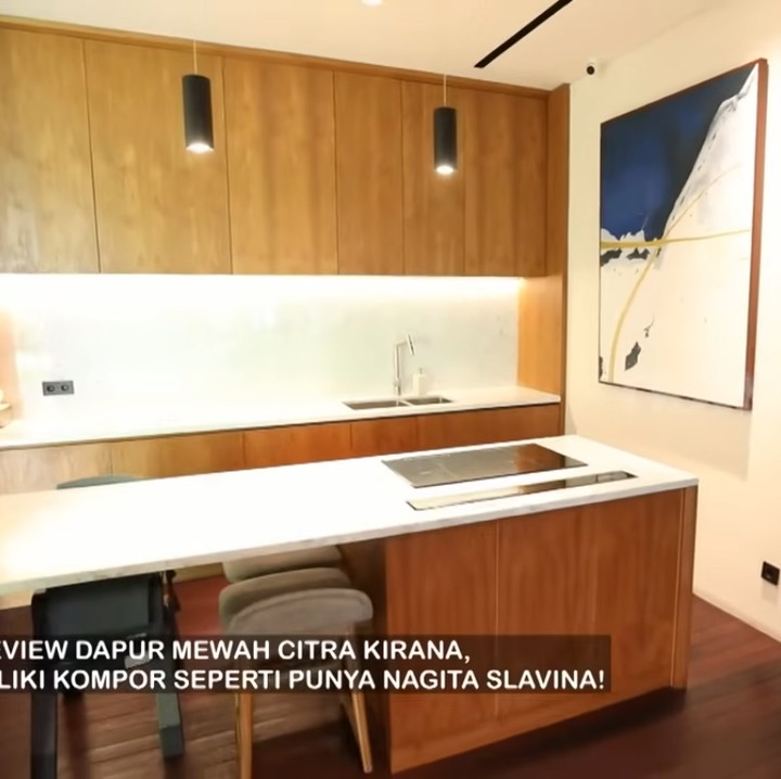 <p>Dapur di rumah Ciki dan Rezky juga menjadi daya tarik karena didominasi dengan kayu. Terdapat pula exhaust kompor induksi yang bisa muncul di permukaan meja. (Foto: YouTube TRANS7 OFFICIAL)</p>