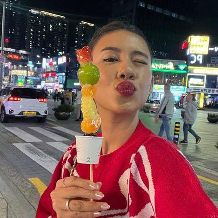 <p>Tampaknya Shenina juga menikmasi suasana kota dengan berkeliling menikmati angin malam. Lewat InstaStory, ia menunjukkan tanghulu, camilan berupa buah-buahan yang ditusuk dan dilapisi sirup gula bening dan keras yang tampaknya baru dibeli. (Foto Instagram @sheninacinnamon)</p>