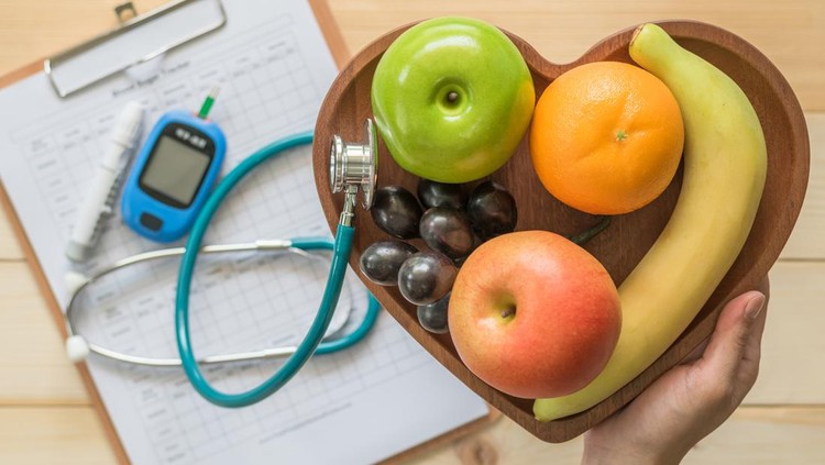 Cholesterol diet and healthy food nutritional concept with clean fruits in heart dish with nutritionist monitoring, blood sugar control record with measuring tool kit