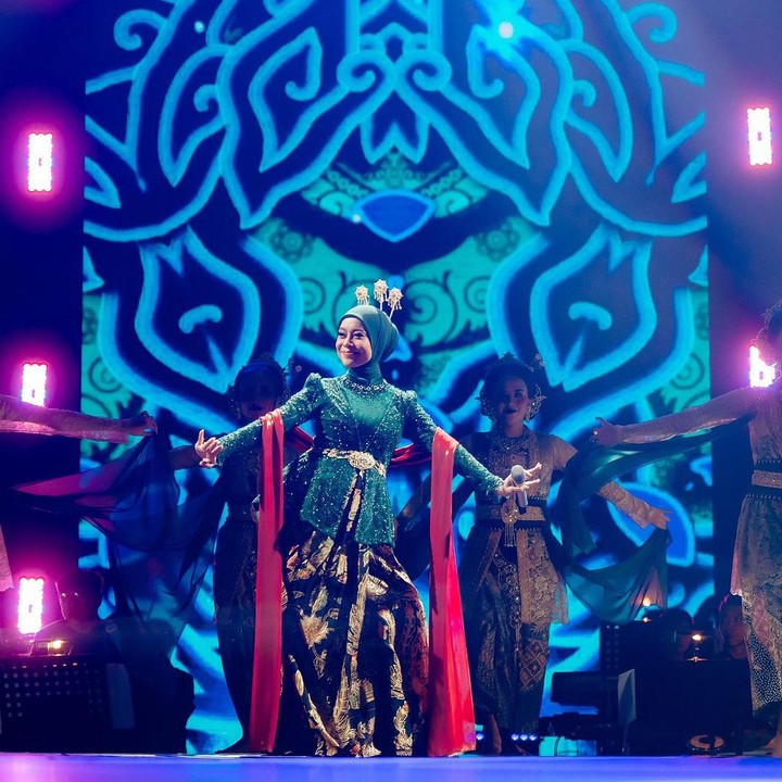 <p>Di salah satu penampilannya, Lesti terlihat anggun mengenakan kebaya Sunda berwarna hijau yang dipadukan dengan kain jarik bercorak cokelat dan dilengkapi aksesoris selendang merah. Dalam balutan baju daerah ini, Lesti yang tengah hamil terlihat begitu prima saat bernyanyi sambil melakukan tarian tradisional. (Foto: Instagram @lestikejora)</p>