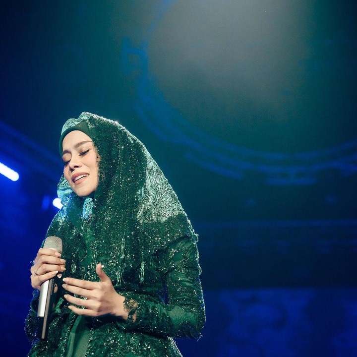 <p>Pakaian lain yang dikenakan Lesti adalah gaun berwarna hijau tua yang kali ini dilengkapi aksesoris penutup kapala veil. Kali ini, <em>baby bump</em> pelantun lagu Kejora itu tidak terlalu terlihat karena tertutup oleh gaun yang dikenakannya. (Foto: Instagram @lestikejora)</p>