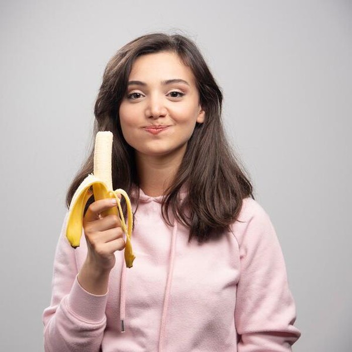Ilustrasi Seorang wanita makan pisang/Foto: freepik.com/azerbaijan_stockers