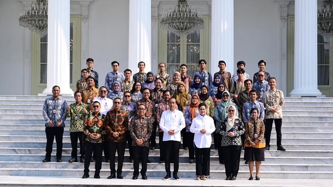 Jokowi mengajak pegawai, petugas kebersihan dan keamanan, hingga pers di Istana Kepresidenan foto bersama di halaman Istana Merdeka, Jakarta, Kamis (10/10).