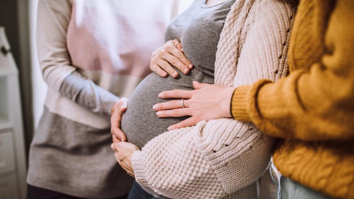 Pregnant Woman Caught in Warm Embrace Of Her Mother And Sister, Enjoying Loving And Affectionate Weekend At Home