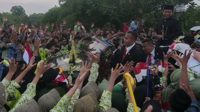 Joko Widodo bersama istrinya Iriana membagi-bagikan kaus kepada sejumlah warga yang menyambut kepulangannya di Solo, Jawa Tengah, pada Minggu (20/10).