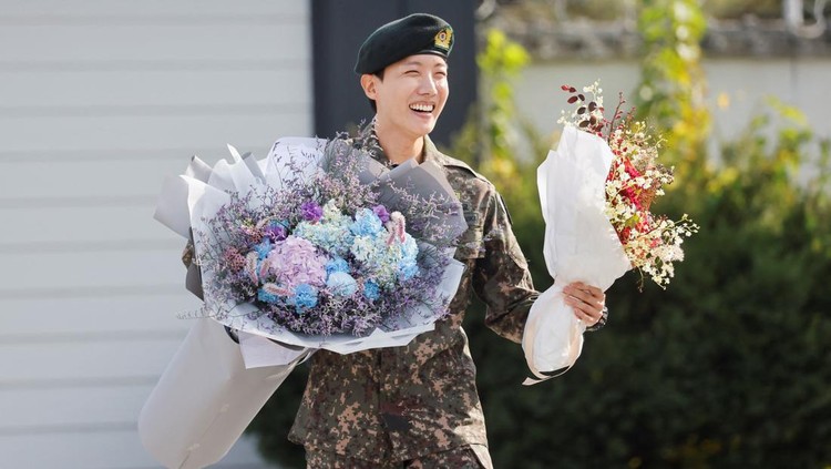 K-pop boy band BTS member J-Hope smiles while holding flowers after being discharged from his 18 months of mandatory military service outside a military base in Wonju, South Korea, October 17, 2024. REUTERS/Kim Soo-hyeon