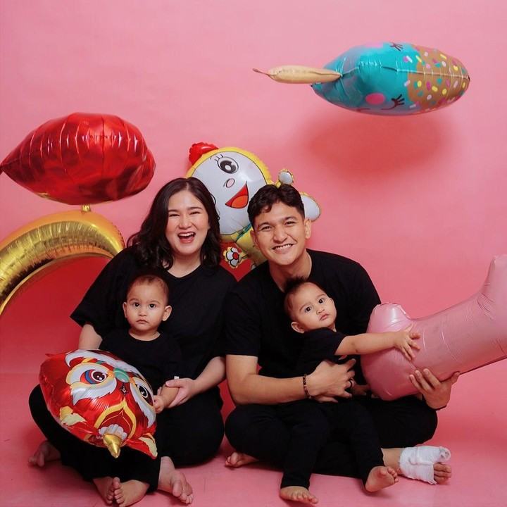 <p>Di foto lainnya, Masayu Clara dan Qausar bersama putra kembar mereka kompak mengenakan pakaian berwarna serba hitam. Dalam foto ini, keduanya duduk berdekatan sambil memegang hiasan balon karakter dengan <em>backdrop</em> berwarna merah muda. Masayu Clara terlihat begitu bahagia dalam foto keluarga ini. (Foto: Instagram @masayuclara)</p>