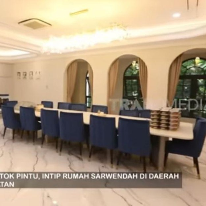 <p>Rumah mewahnya ini didominasi dengan warna putih dan hitam. Untuk ruang makannya, Sarwendah memiliki meja makan yang panjang yang dilengkapi dengan kursi berwarna biru. (Foto: YouTube TRANS7 OFFICIAL)</p>