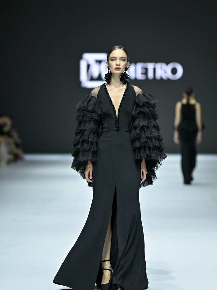 Visual yang bold pada busana didapatkan tak hanya dari motif dengan warna-warni memikat terinspirasi dari kafe di kota Paris tersebut, tapi juga potongan A-line yang anggun hingga aksen ruffles yang dramatis/ Foto: Dok. JFW
