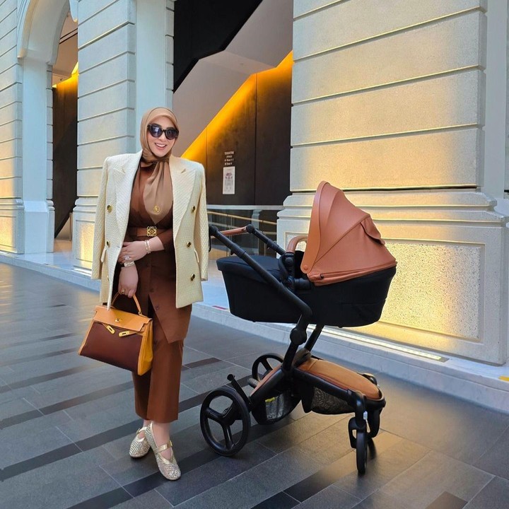 <p>Setelah melahirkan, transformasi Syahrini tak banyak berubah. Tetap cantik dan fashionable banget. Perempuan berusia 44 tahun ini tampil stylish dengan memadukan blazer krem dan setelan serba cokelat. Mulai dari pakaian celana sampai hijabnya. Syahrini mempermanis penampilannya dengan kacamata hitam dan tas mewah berwarna cokelat. Outfit-nya sangat cocok dengan stroller sang putri yang diajak jalan-jalan. Foto: Instagram: @princessyahrini</p>