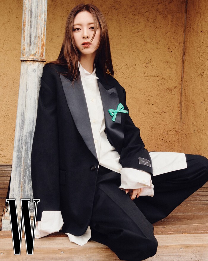 Tampil elegan dan chic, anggota ITZY tersebut memadukan suit dari Coach dengan dalaman kemeja putih klasik dan celana hitam yang ramping, menciptakan kesan sophisticated dan berkelas. Ia menambahkan aksesori pita pada suit, memberikan sentuhan unik./ Foto: W Korea