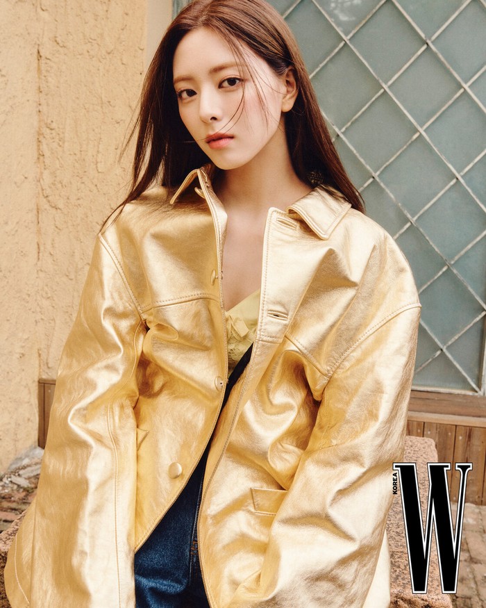 Yuna tampil cerah dan cantik dengan jaket kulit berwarna kuning yang mencolok, menambahkan kesan bold pada gayanya. Warna kuning yang vibrant ini membuat Yuna terlihat standout, menciptakan tampilan yang fresh dan menyenangkan./ Foto: W Korea
