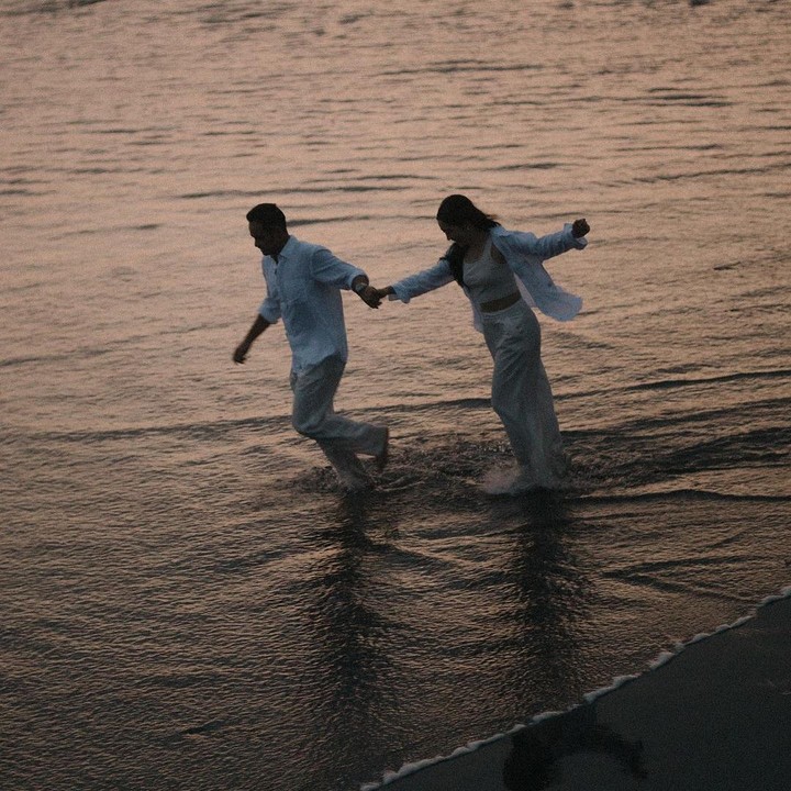 <p>Di foto lainnya, Febby dan Drajad Djumantara kompak mengenakan pakaian berwarna serba putih. Keduanya terlihat romantis berpegangan tangan kala menikmati momen bersama di pantai. (Foto: Instagram @febbyrastanty)</p>