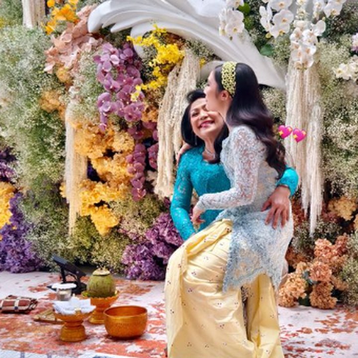 <p>Pada potret lainnya, Febby terlihat duduk di pangkuan sang Ibunda, Anice Worang. Anice tampil mengenakan kebaya tosca dan rok batik warna senada. (Foto: Instagram: @yukikt)</p>