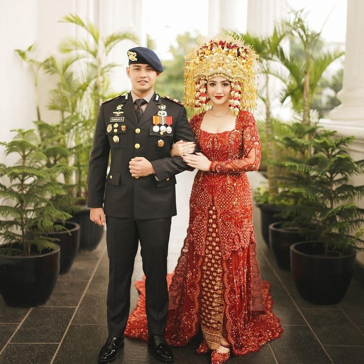 <p>Resepsi pernikahan Febby dan sang suami diawali dengan upacara pedang pora. Sang suami terlihat gagah mengenakan seragamnya, sedangkan Febby tampil elegan dengan kebaya warna merah dari Studio Boh. (Foto: Instagram@thebridestory)</p>