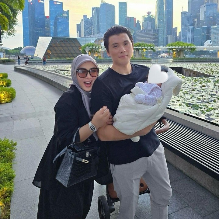 <p>Syahrini dan Reino terlihat kompak dengan mengenakan setelah serba hitam dan abu-abu. Sementara Baby R tampil dengan pakaian serba putih. (Foto: Instagram: @princessyahrini)</p>