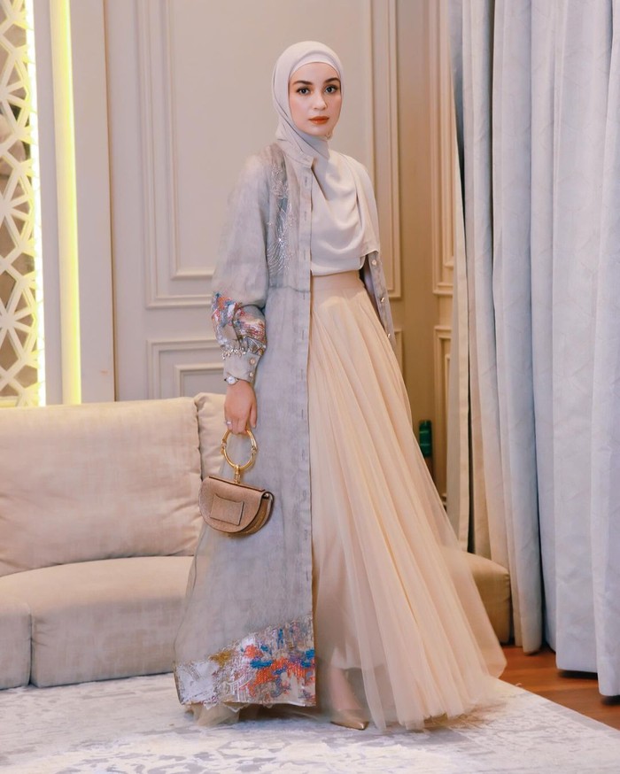 Tampil anggun dengan outer abu-abu panjang yang matching sama kerudungnya, Shireen Sungkar melengkapinya dengan rok tulle peach yang manis serta tas cokelat dan heels senada (Shireen Sungkar/Foto: instagram.com/shireensungkar)
