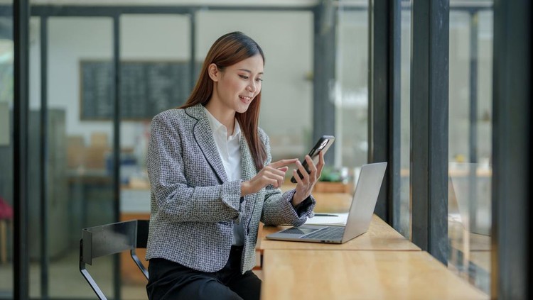 Ilustrasi wanita karier menggunakan ponsel atau WhatsApp di kantor