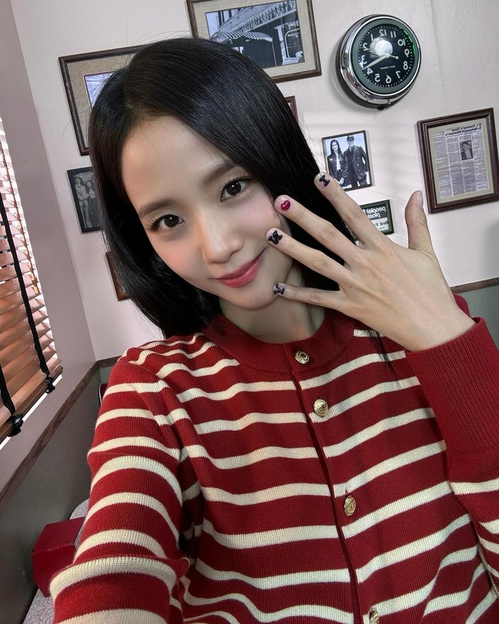 Jisoo kenakan outfit cardigan bergaris merah basic yang tidak akan ketinggalan zaman. Tampilan ini cocok dipadukan dengan celana denim untuk tampilan kasual, atau menambahkan rok lipit untuk gaya klasik./ Foto: Elle Korea