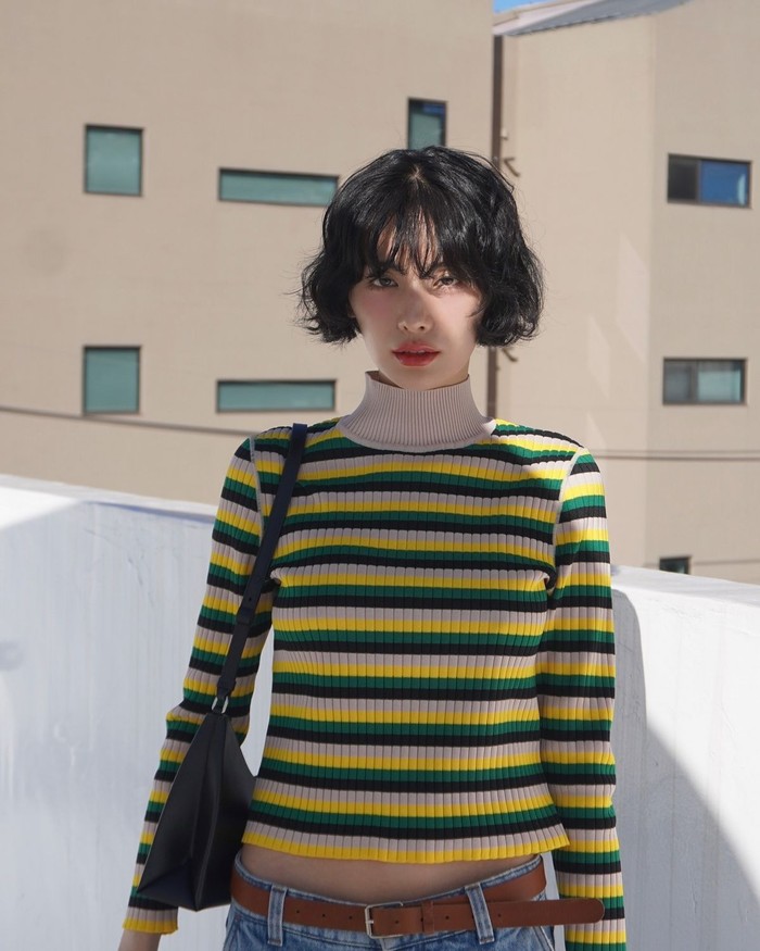 Nana memadukan atasan turtleneck dengan kombinasi warna beragam dan celana denim untuk menciptakan suasana berjiwa bebas. Outfit ini cocok dengan gaya rambutnya yang menonjol./ Foto: Elle Korea