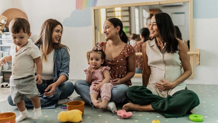 Mothers talking while their babies playing in the playroom