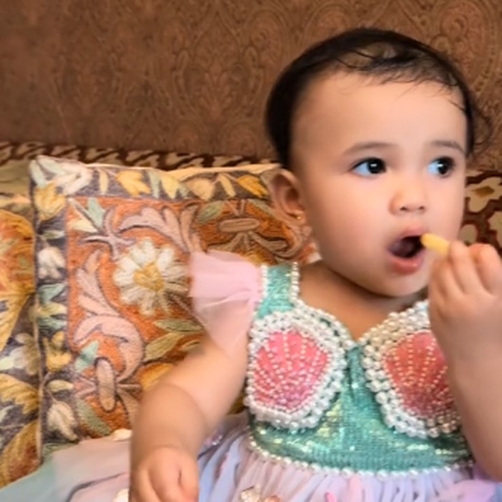 <p>Pada acara ulang tahunnya ini, Azura terlihat cantik dengan gaun ala p<em>rincess mermaid</em>, Bunda. Tidak peduli dengan sekitar yang asyik konser dadakan, Azura justru asyik makan, nih. Gemas banget, ya! (Foto: TikTok: @attahalilintar)</p>
