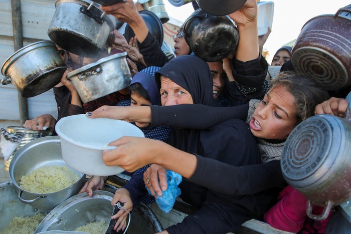 Palestinians gather to receive food cooked by a charity kitchen, amid a hunger crisis, as the Israel-Gaza conflict continues, in Khan Younis in the southern Gaza Strip, November 19, 2024. REUTERS/Hatem Khaled