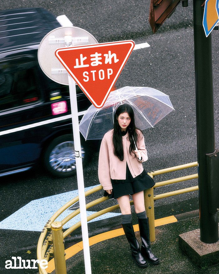 Seperti tokoh anime, Shin Ye Eun kenakan blouse hitam yang dilengkapi outer pink, celana pendek flare berbahan wol, dan kaus kaki selutut dari O’2nd. Ia memadukannya dengan sepatu bot panjang hitam untuk menambah kesan feminin. / Foto: Allure Korea