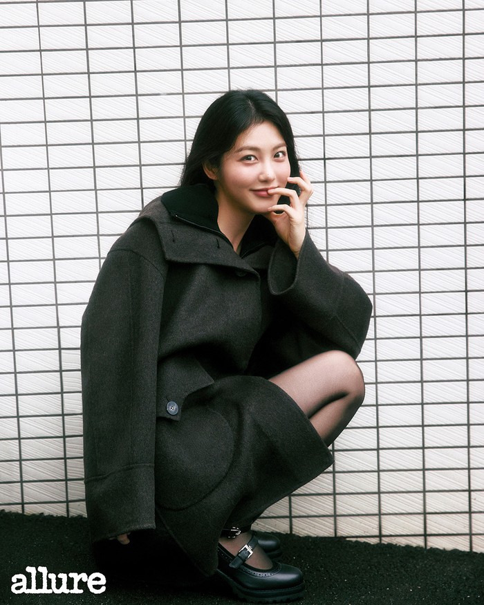 Tampil hangat dan elegan, Shin Ye Eun melengkapi outfit-nya dengan mantel wol Rams, kardigan leher tinggi, dan sepatu hak tali dari O’2nd, membuatnya terlihat chic dengan senyumnya yang manis. / Foto: Allure Korea