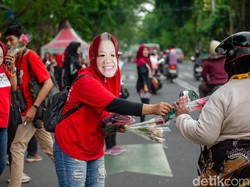 Relawan JAKA Pakai Topeng Risma Kampanye Bagi-bagi Bunga