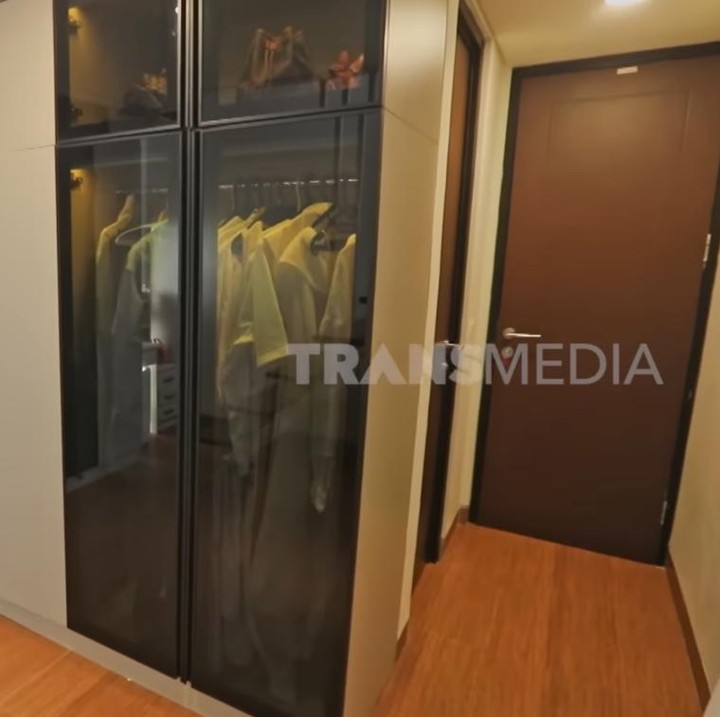 <p>Masih di lantai yang sama, Dewi juga menyediakan satu ruangan untuk <em>walk-in closet.</em> Meski tidak terlalu besar, ruangan ini muat untuk menyimpan koleksi barang-barang<em> branded-</em>nya. (Foto: YouTube TRANS7 OFFICIAL)</p>