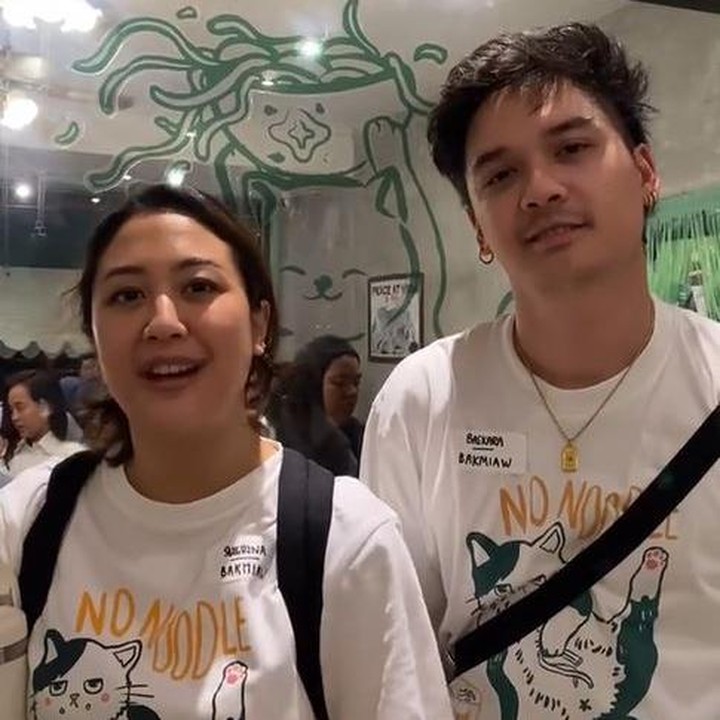 <p>Dalam acara ini, Sherina dan Baskara kompak mengenakan pakaian yang sama, yakni kaos putih dengan gambar kucing sebagai tema ulang tahun hari itu. Baik Sherina dan Baskara terlihat santai kala mengahadiri perayaan ulang tahun bisnis bakmi ini. (Foto: Instagram @bakmiaw_)</p>