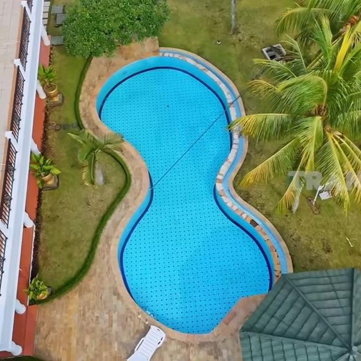 <p>Di samping rumah utama, Inggrid membangun kolam renang luas yang dikelilingi pepohonan dan pemandangan hijau tanaman. Di sekitar kolam renang juga disediakan tempat bersantai. (Foto: YouTube TRANS7 OFFICIAL)</p>