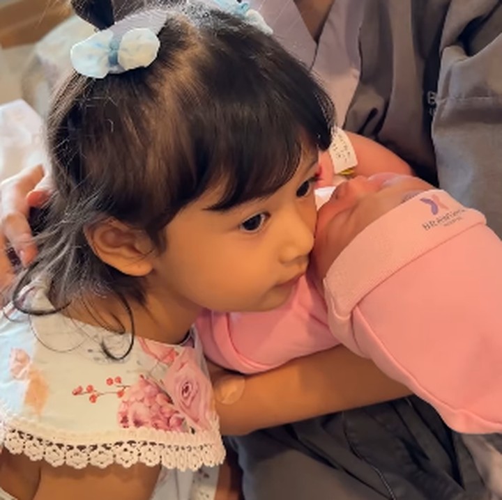 <p>Ketika sang adik diantarkan ke dalam kamar, Mikaila terlihat tersenyum. Sesekali ia mengelus dan menggendong adik perempuannya tersebut dengan penuh sayang. (Foto: Instagram: @nonawilly16)</p>
