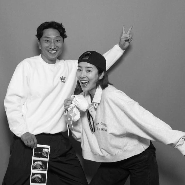 <p>Dengan nuansa hitam putih, Son Dam Bi terlihat energik di usia 41 tahun ini. Bersama sang suami, ia tersenyum bahagia sembari memamerkan foto USG ke para <em>followers</em>-nya. (Foto: @xodambi)</p>