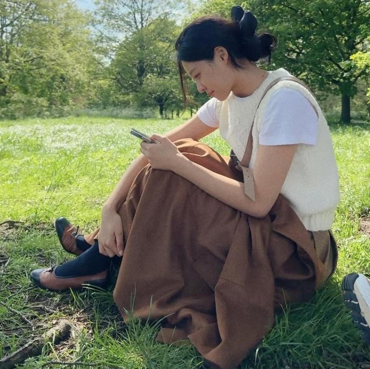 <p>Bila Bunda mencari ide outfit santai kala ke taman, cobalah untuk mengenakan kaus putih <em>basic</em> berlapis rompi rajut krem lalu padukan dengan rok cokelat panjang. Tampilan Seolhyun yang satu ini bernuansa kasual nan manis. (Foto: Instagram @s2seolhyuns2)</p>